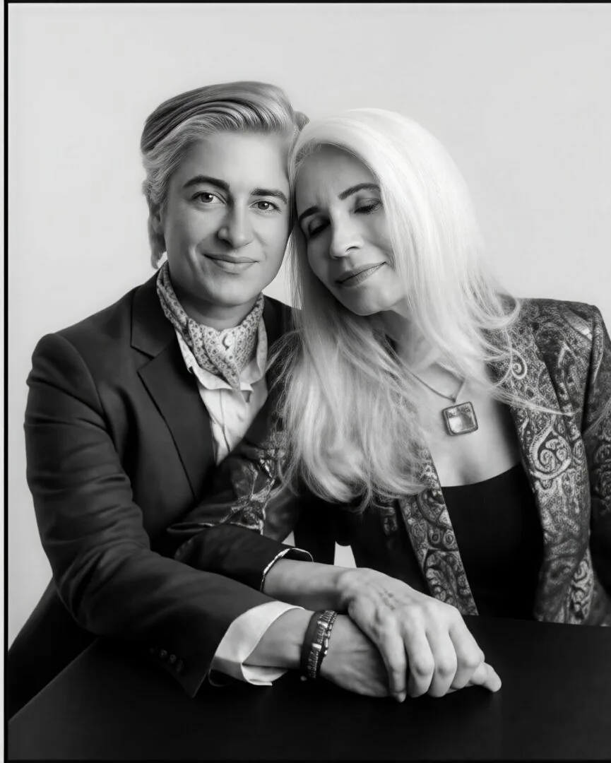 Ruth and her daughter Candice, both silver-haired, sitting close together in a black and white portrait