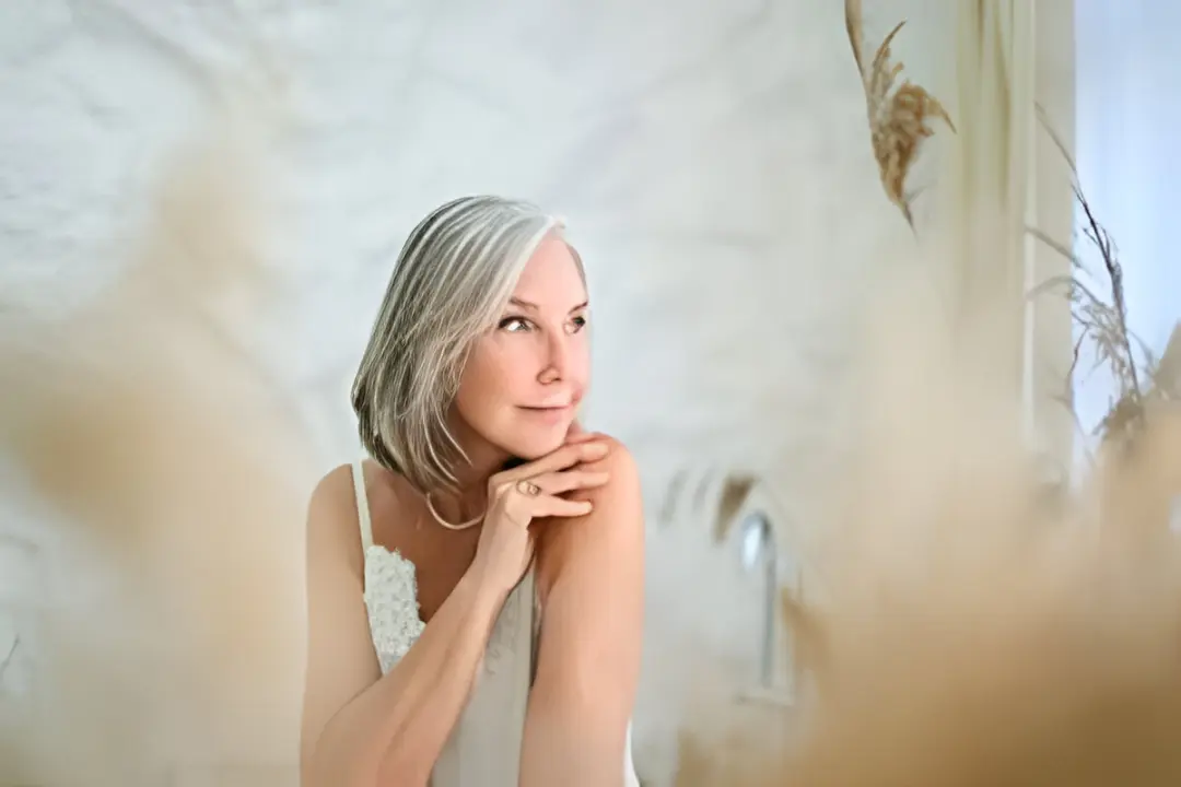 Woman with gray hair in serene setting.